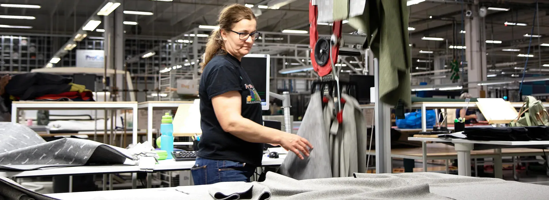 En operatör vid en produktionslinje där plagg bärs på Eton Systems transportörer
